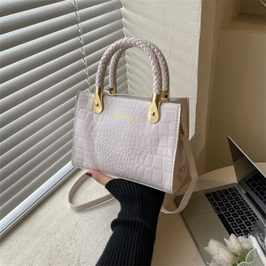Chic beige crocodile embossed handbag with woven handle and adjustable crossbody strap