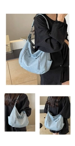 Detailed views of the light blue crescent bag showing front zippers and soft matte texture