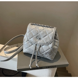 Details des silbernen gesteppten Minirucksacks mit Metallkette und Drehverschluss