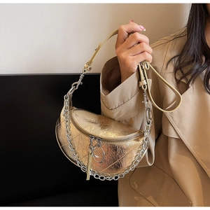 Detail of golden crescent shoulder bag with metallic wrinkled texture and chain strap