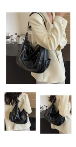 Detail of black crescent hobo bag with silver zippers and slouchy leather texture