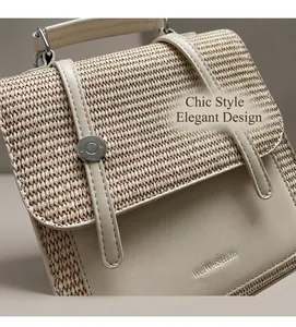 Close-up of beige woven straw and smooth faux leather handbag with embossed brand logo
