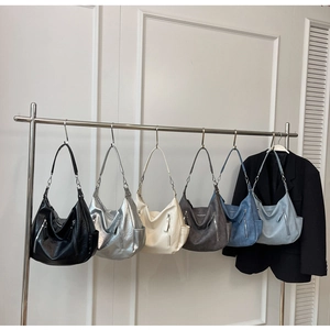 Collection of minimalist crescent shoulder bags in six colors with decorative side zippers