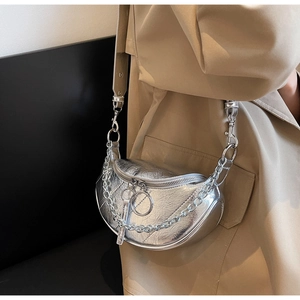 Detail view of silver crescent bag featuring wrinkled texture and chunky metal chain