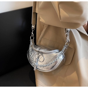 Close-up of silver crescent bag with metallic crinkle texture and chunky chain strap