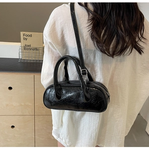 Close-up of black glossy patent leather bowling bag with vintage wrinkled texture details