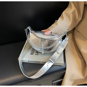 Close-up of metallic silver crescent bag with chunky chain and crinkled texture leather