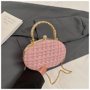 Detail of pink tweed handbag with golden metal handle and crystal ball clasp