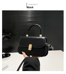 Detail of black leather square bag with gold metal twist lock and circular handle