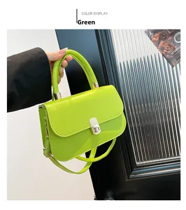 Detail of a bright green saddle bag with silver lock and adjustable shoulder strap
