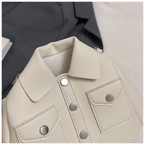 Detail of creative shirt-shaped leather bag with collar and metal buttons