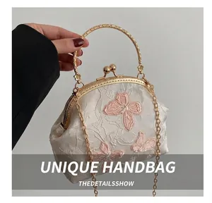 Close-up of vintage embroidery tote with floral patterns and a gold metal handle