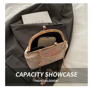 Interior view showing capacity of embroidered handbag with smartphone and gold frame