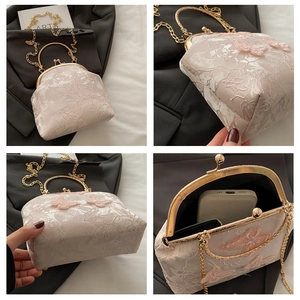 Detailed close-up of cream lace bag with butterfly floral patterns and gold chain