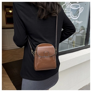Close-up of brown crossbody phone bag with white stitching shown on model back