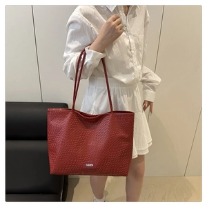 Détail de la texture tressée rouge sur un grand sac cabas avec étiquette Fashion