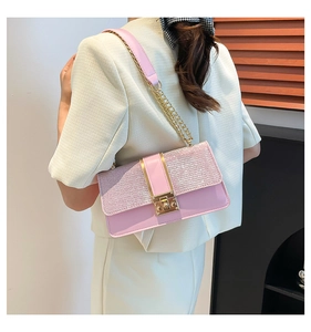 Détail du sac à bandoulière rose à paillettes avec chaîne dorée et boucle métallique