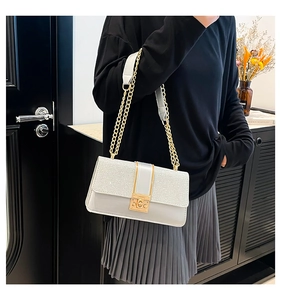 Detail of silver sequin glitter bag with gold square twist lock and metal chain strap