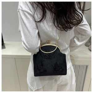 Back view of a woman wearing the vintage black lace butterfly bag with a gold chain