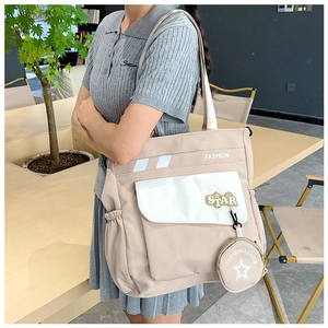 Détail d'un grand sac fourre-tout abricot avec écussons étoiles blancs et petit porte-monnaie