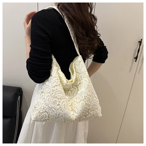 Sac hobo en dentelle blanche avec broderie florale porté à l'épaule pour la taille