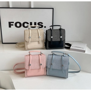 Detail view of woven leather mini backpacks in beige, black, pink, and sky blue colors