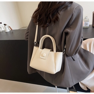 Detail of cream leather handbag texture with top handle and detachable shoulder strap