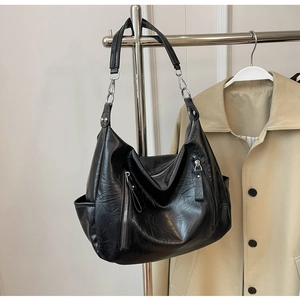 Detail van zwarte Hobo-tas met vintage geplooide textuur en zilveren ritsen aan de voorkant
