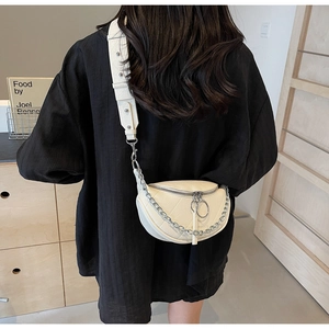 Detailed back view of a white crescent saddle bag with V-quilt stitching and chain strap