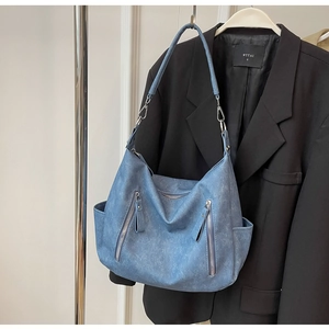 Detail van lichtblauwe denim Hobo tas met zilveren ritsen en een brede schouderriem