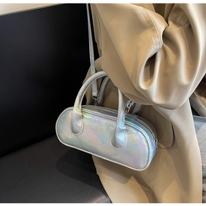 Detail shot of a silver holographic bowling bag featuring top handles and a thin strap