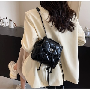 Nahaufnahme eines schwarzen gesteppten Mini-Rucksacks aus Leder mit Kettenriemen