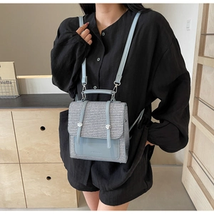 Mini straw backpack featuring light blue leather trim and grey woven texture detail