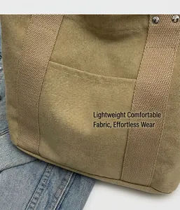 Dettaglio ravvicinato della borsa tote in tela kaki con tasca frontale e rivetti argento