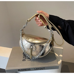 Close-up of metallic gold dumpling bag with pleated texture and silver chain strap