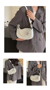 White crescent underarm bag with pearl heart chain detail on grey blazer