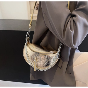 Detail of metallic gold crescent bag with wrinkled texture and chunky silver chain
