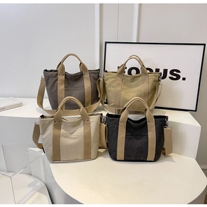 Borse tote in tela in quattro colori con manici e tracolle su supporti bianchi