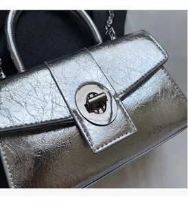 Detailed close-up of silver cracked texture leather bag with metallic oval twist lock