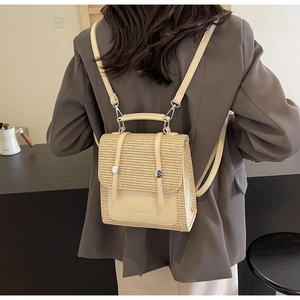 Model view of a beige woven straw backpack with premium leather trim and straps