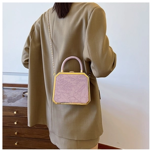 Detail view of lavender faux leather crossbody bag with floral embossing and gold chain