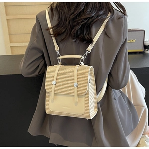 Close-up of beige woven straw backpack with synthetic leather trim and silver buckles