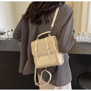 Detail of straw and leather patchwork backpack with silver buckle and woven texture