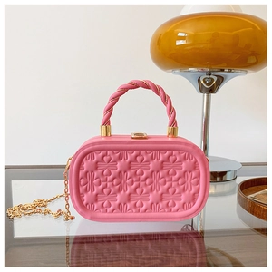 Detalle del relieve de corazón rosa en el bolso de mano rígido elegante y estructurado