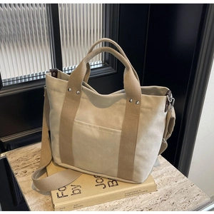 Dettaglio borsa in tela kaki con tracolla regolabile e finiture in pelle di alta qualità