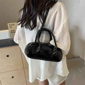 Minimalist black patent leather bowling bag with top handles and shoulder strap