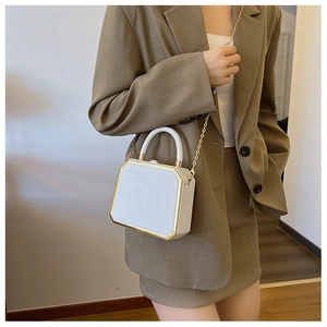 Detail of white octagonal crossbody bag with floral embossing and gold chain strap