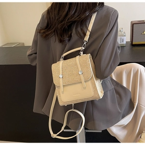 Close-up of beige woven straw backpack with leather flap and silver buckle detail
