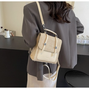 Detail showing handwoven straw texture and leather buckles on a chic summer backpack