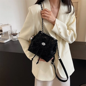 Gesteppter Mini-Rucksack mit silberner Kette, getragen von einem Model im beigen Blazer